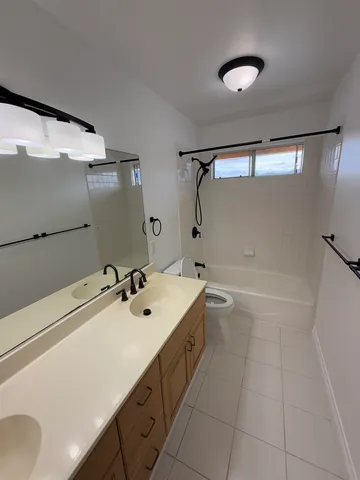 a bathroom with a double vanity sink and mirror with shower