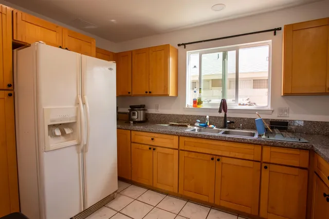 a kitchen with stainless steel appliances granite countertop a refrigerator sink and cabinets