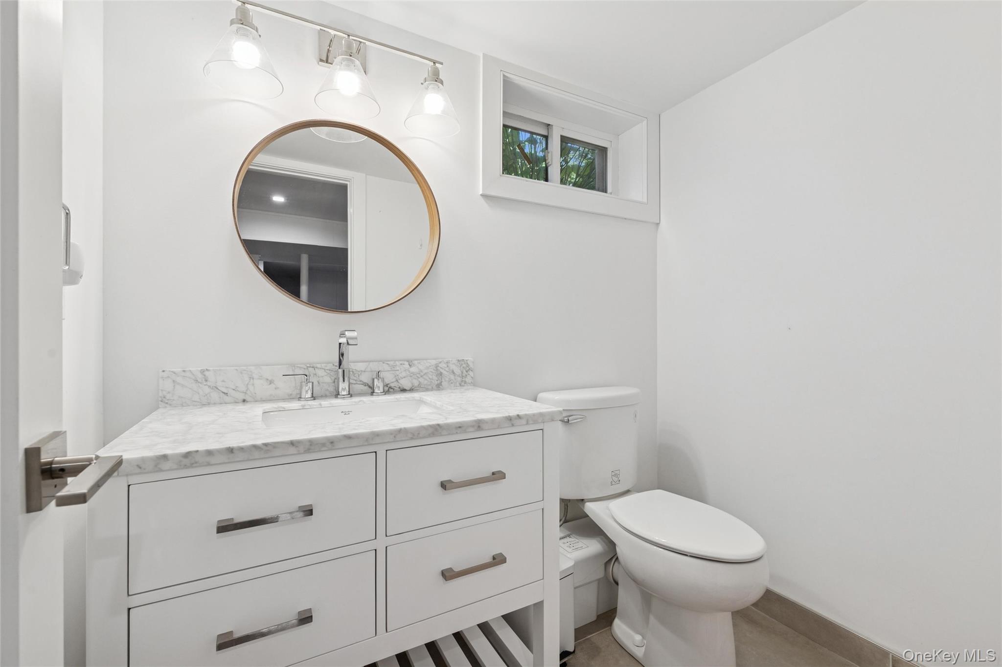 4 Morris Court Westhampton Beach, NY 11978 - Photo 20 of 28 a bathroom with a granite countertop toilet a sink and a mirror