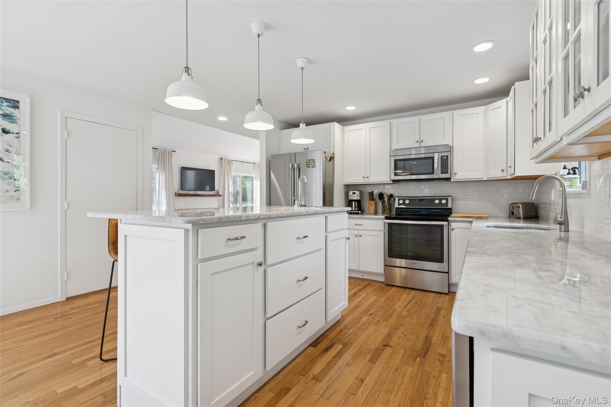 4 Morris Court Westhampton Beach, NY 11978 - Photo 9 of 28 a kitchen with kitchen island granite countertop a sink cabinets and stainless steel appliances