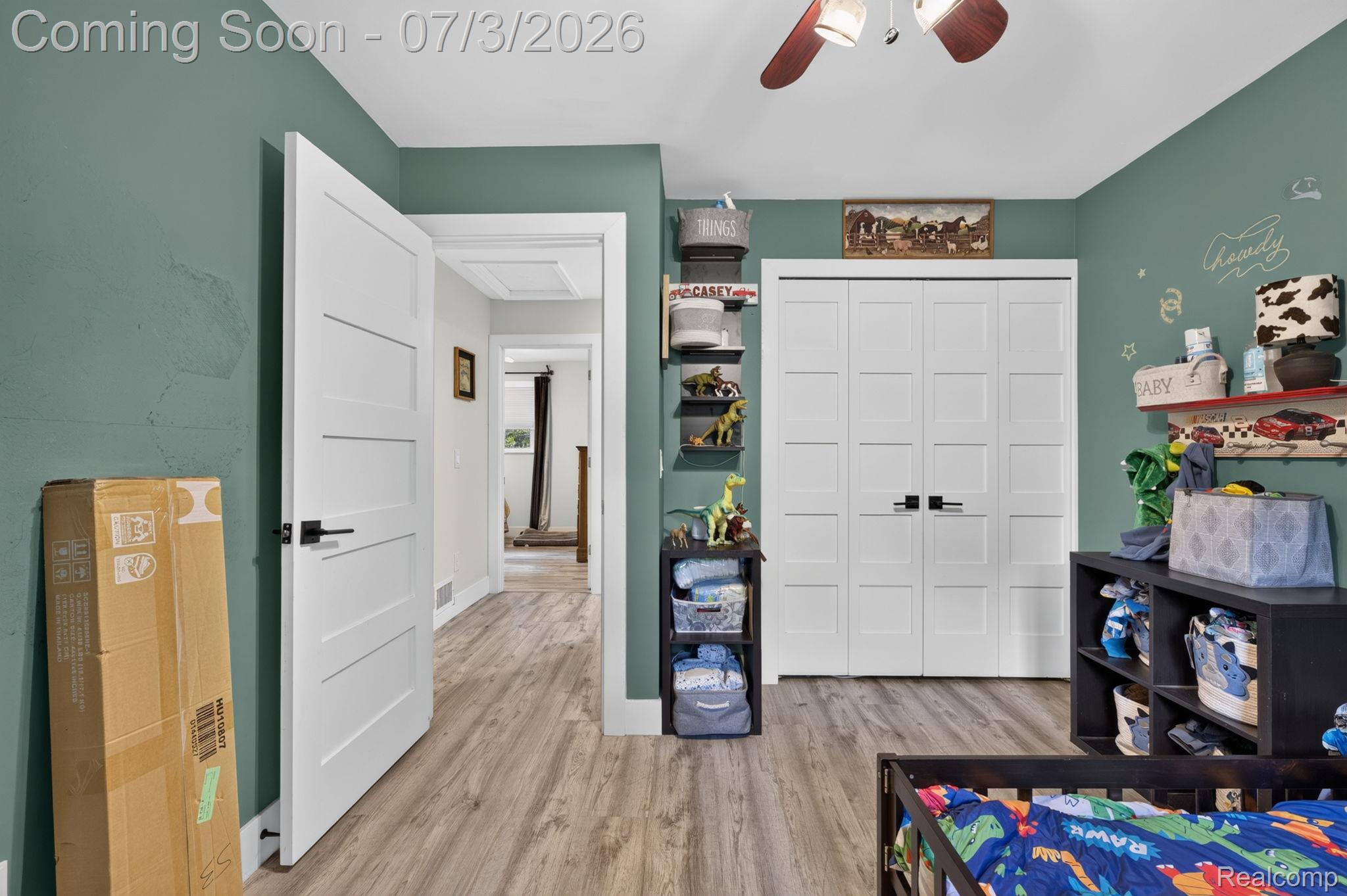 5355 North Seymour Road Flushing, MI 48433 - Photo 25 of 41 Interior room featuring wood-finish flooring, a ceiling fan with light, modern interior doors with dark hardware, and a closet with bifold doors