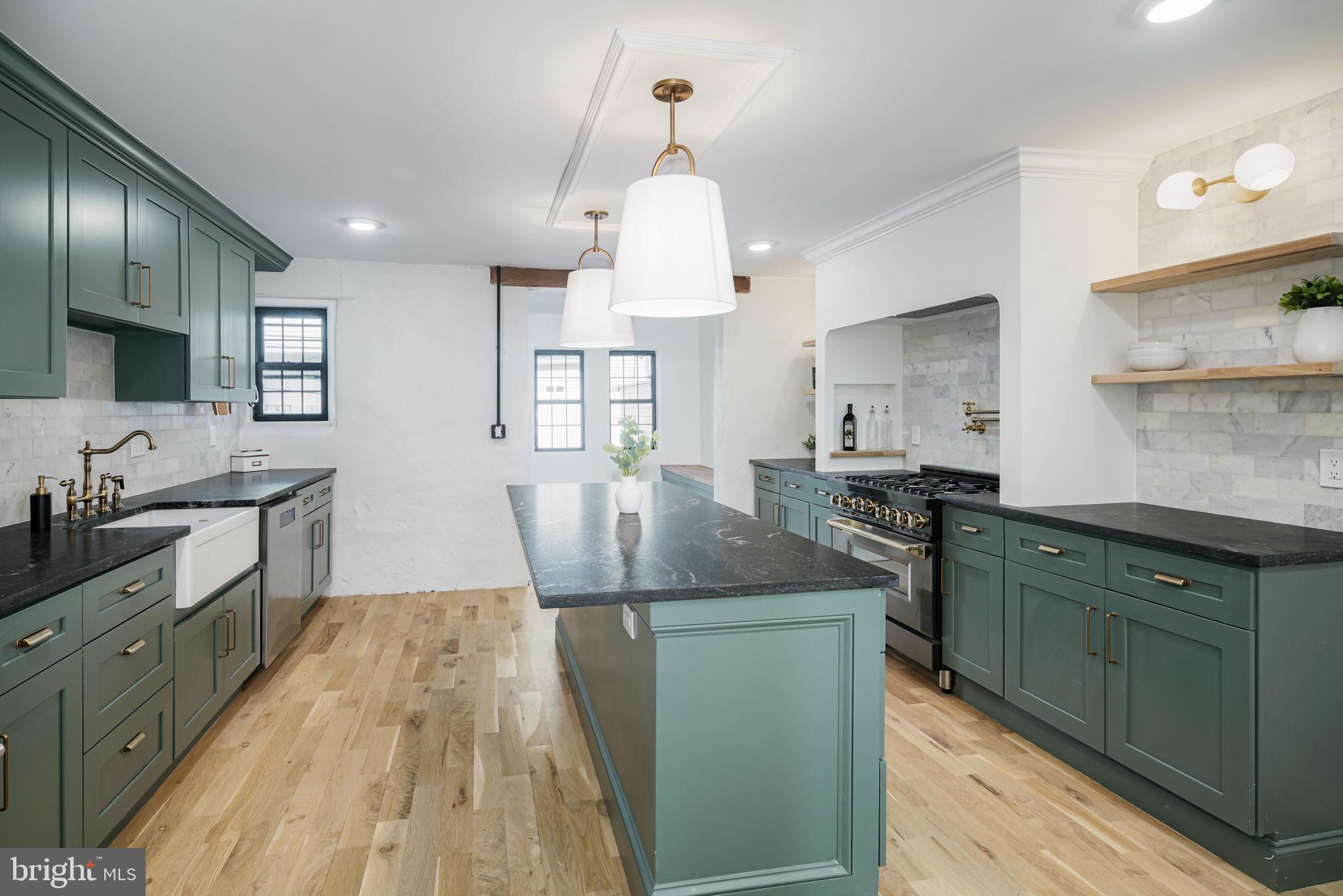 a kitchen with kitchen island granite countertop a sink and wooden floor