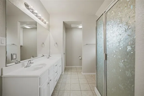 a spacious bathroom with a double vanity sink a mirror and a shower