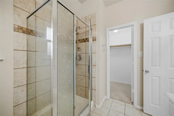 a bathroom with a shower and a glass door