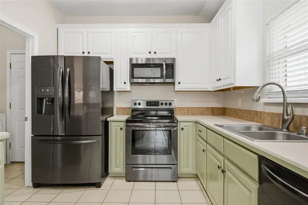 a kitchen with stainless steel appliances granite countertop a refrigerator stove and sink