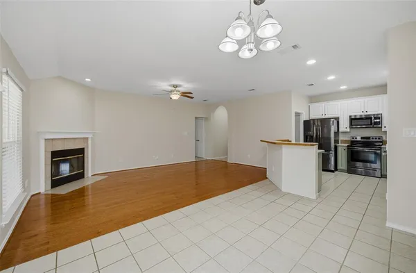 a view of kitchen with granite countertop cabinets and refrigerator