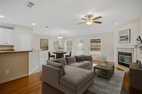 a living room with furniture a fireplace and wooden floor