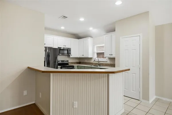 a kitchen with kitchen island granite countertop a sink and a stove top oven with wooden floor