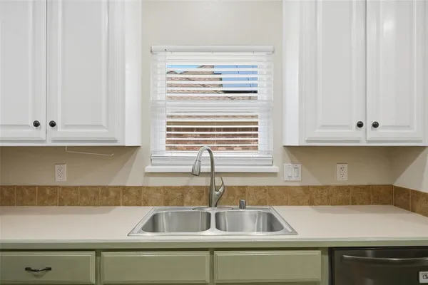 a kitchen with granite countertop a sink and a white cabinets