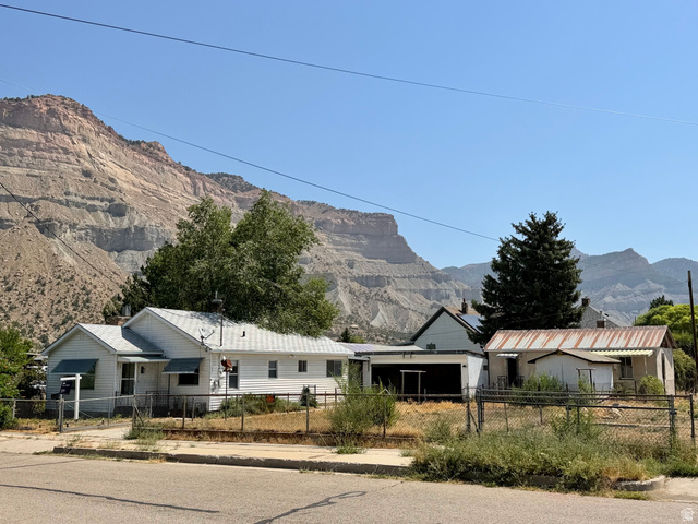 151 South Roosevelt Helper, UT 84526 - Photo 1 of 20 White siding residence with a fenced front yard and asphalt shingle roof