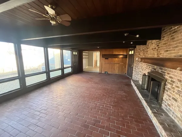 a view of empty room with wooden floor and fireplace