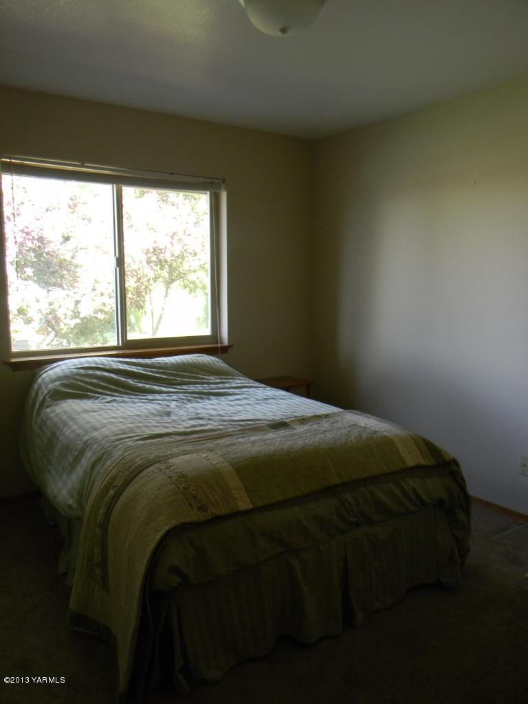1805 Ekelman Road Yakima, WA 98901 - Photo 6 of 16 a bed sitting in a bedroom next to a window