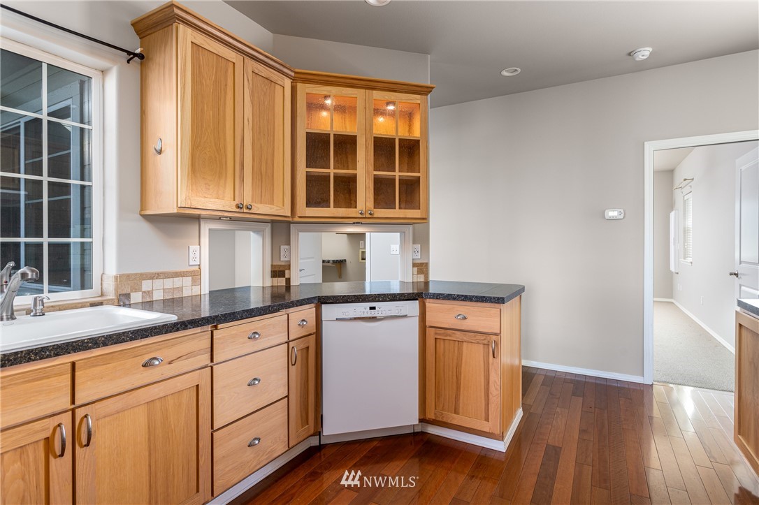 704 Firing Center Road Yakima, WA 98901 - Photo 11 of 29 a kitchen with granite countertop wooden cabinets stainless steel appliances a sink and a window