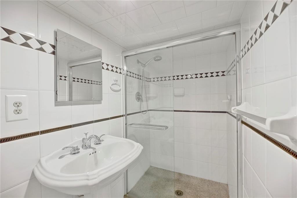 7607 Colonial Road Brooklyn, NY 11209 - Photo 28 of 35 a bathroom with a sink a shower and a mirror