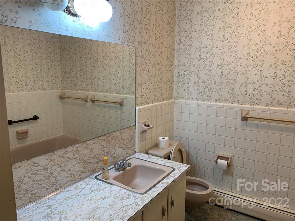 3170 Spring Garden Road, Unit 112 Claremont, NC 28610 - Photo 26 of 36 a bathroom with a granite countertop toilet and sink