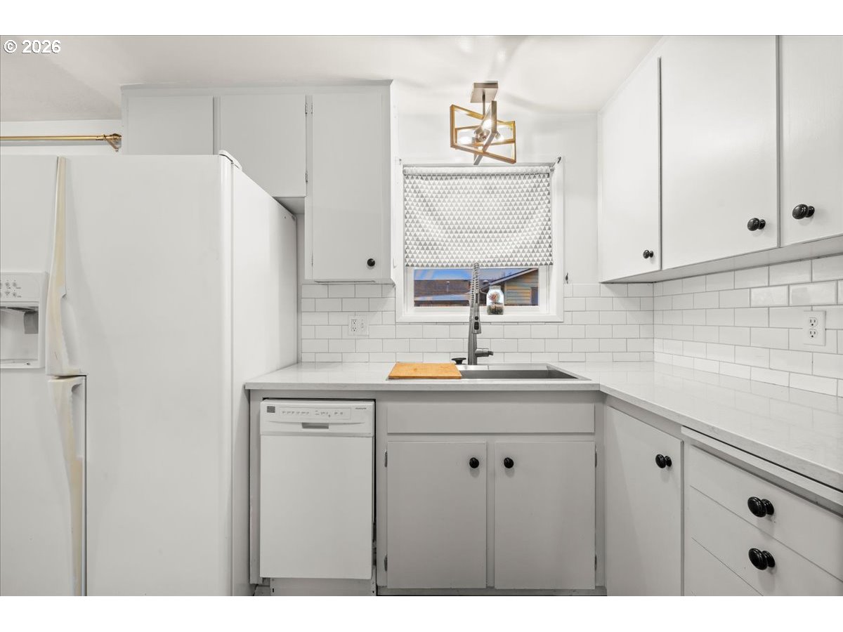 1386 Umpqua Road Woodburn, OR 97071 - Photo 12 of 32 a kitchen with a sink and a refrigerator