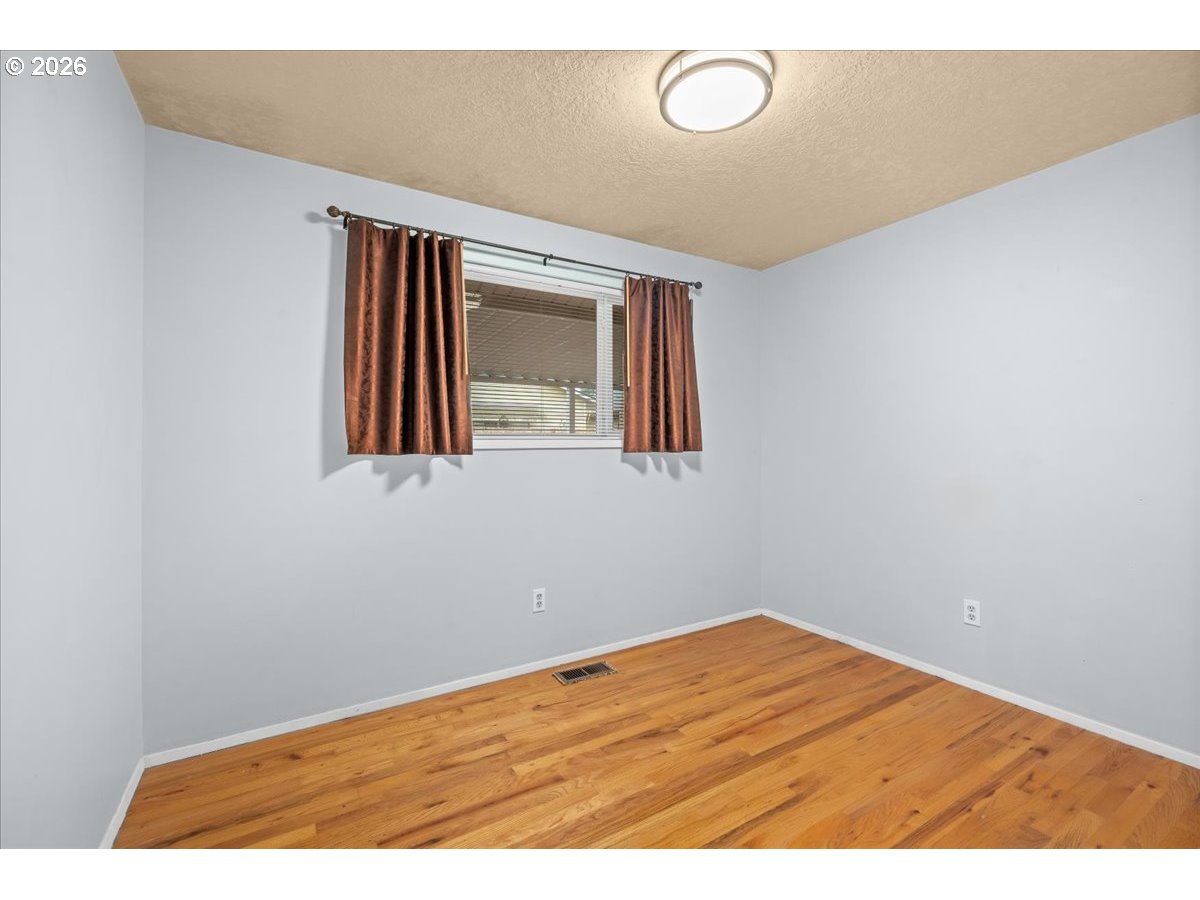 1386 Umpqua Road Woodburn, OR 97071 - Photo 16 of 32 a view of empty room with wooden floor