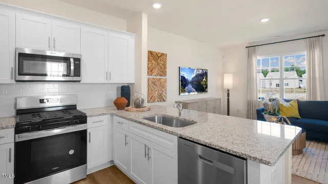 a kitchen with granite countertop a sink stainless steel appliances and cabinets