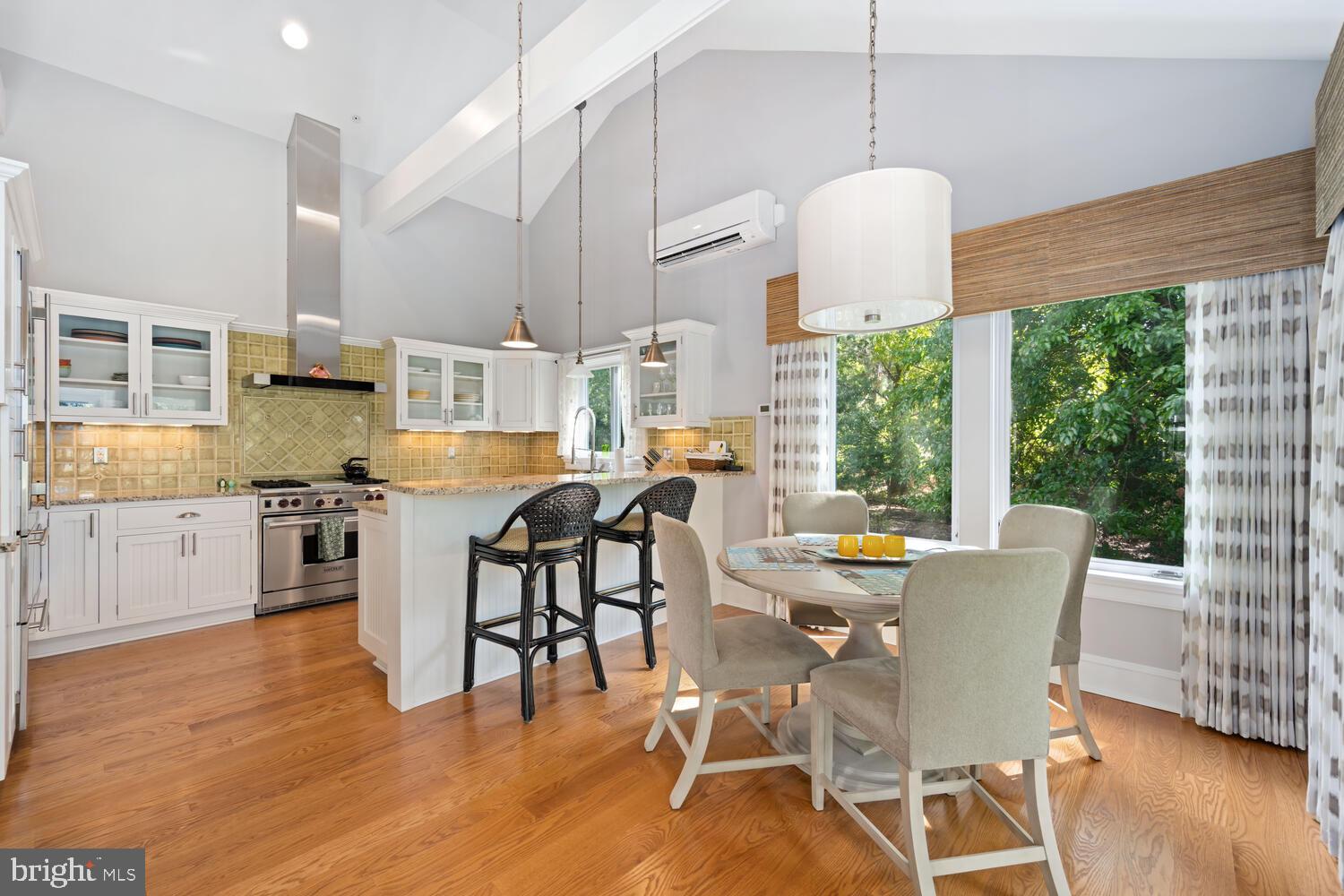 7508 Cooper Point Road Bozman, MD 21612 - Photo 103 of 116 a dining room with stainless steel appliances granite countertop a table chairs and a wooden floor