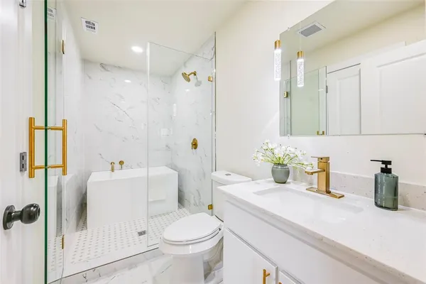 a bathroom with a sink a toilet and shower