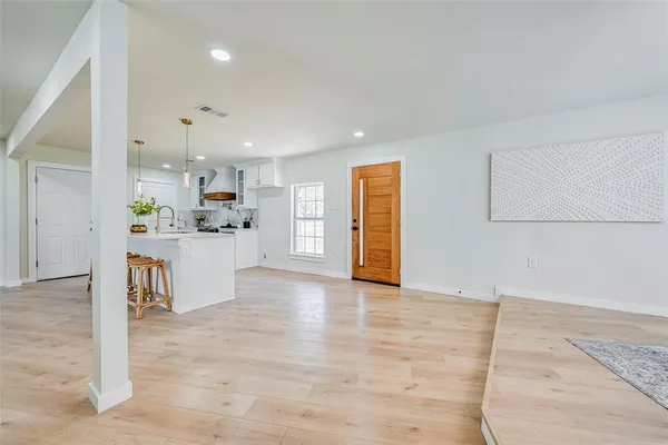 a view of kitchen with kitchen island microwave and cabinets