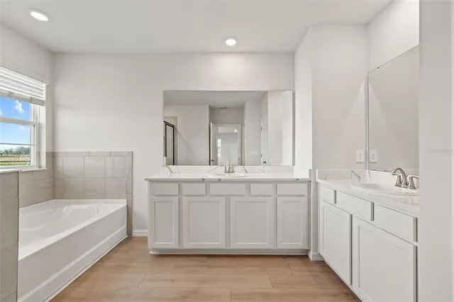 a white bath tub sitting next to a shower