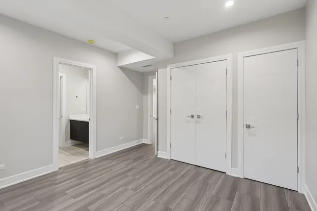 a view of an empty room with wooden floor and closet