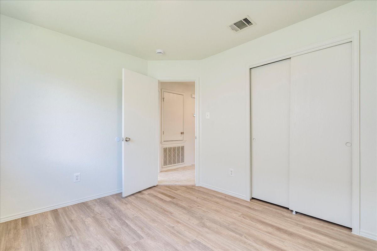 100 Easy Street Hutto, TX 78634 - Photo 19 of 36 Newly laid wood flooring and a deep closet define this bright, versatile bedroom.