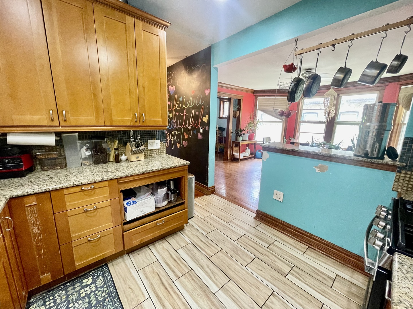 7916 South Constance Avenue Chicago, IL 60617 - Photo 15 of 28 a kitchen with granite countertop wooden cabinets a stove and a window