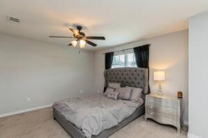 218 Wainwright Drive Crestview, FL 32539 - Photo 15 of 42 a bedroom with a bed and a chandelier