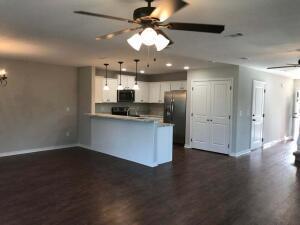 218 Wainwright Drive Crestview, FL 32539 - Photo 36 of 42 an open kitchen with a refrigerator wooden floor and a ceiling fan
