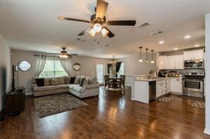 218 Wainwright Drive Crestview, FL 32539 - Photo 7 of 42 a living room with couches and kitchen view with wooden floor