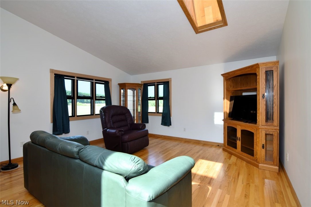 15227 Leroy Road Thompson, OH 44086 - Photo 37 of 50 Family room with hardwood floors, Andersen windows, skylight and ceiling fan. Open to the kitchen and morning room.