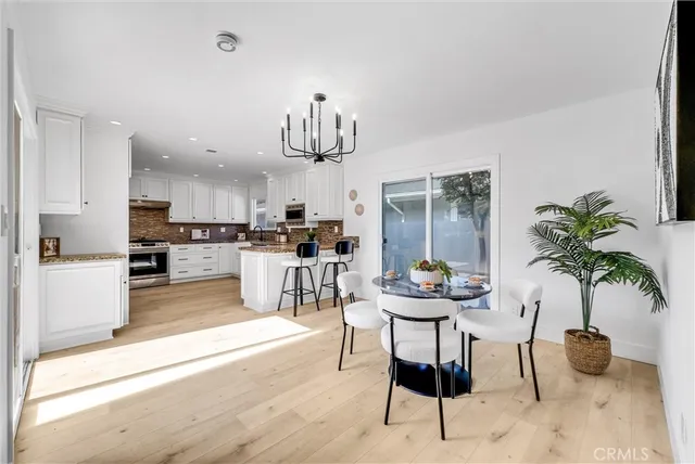 a kitchen with stainless steel appliances kitchen island granite countertop a refrigerator and a dining table