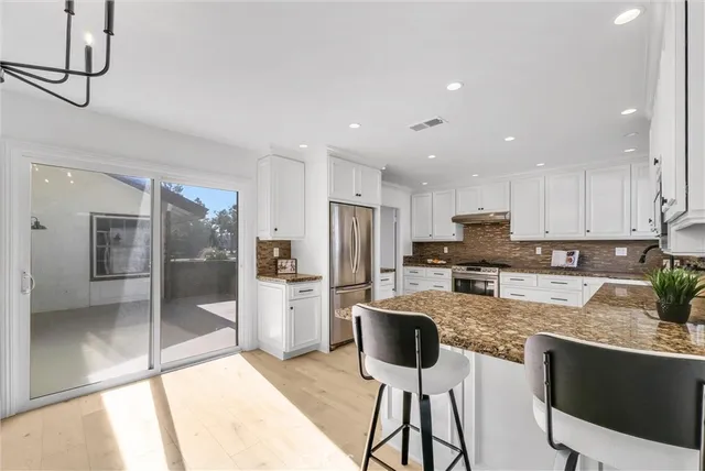 a kitchen with stainless steel appliances granite countertop a stove refrigerator sink and cabinets