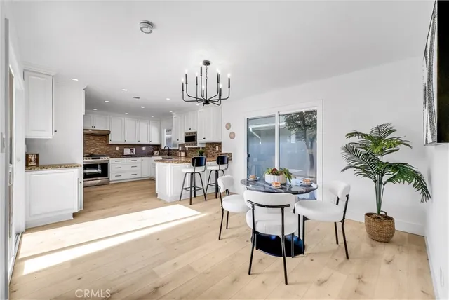 a kitchen with stainless steel appliances kitchen island granite countertop a refrigerator and a dining table