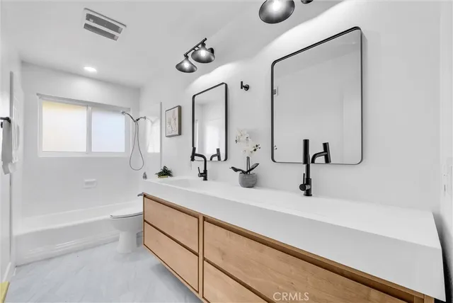 a dining room with chandelier fan and wooden floor