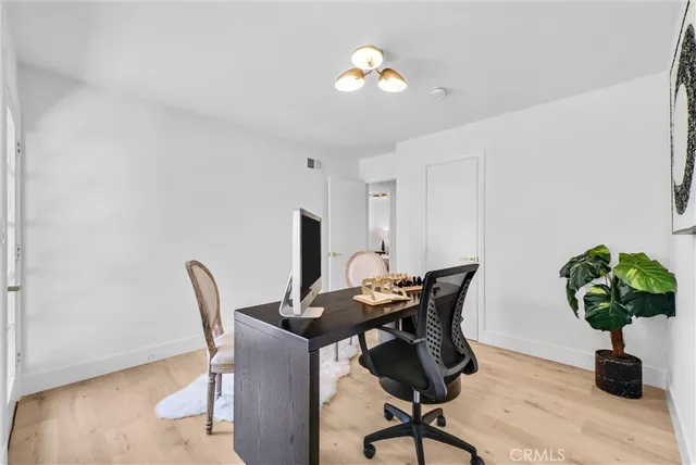 a view of a hallway with dining room and wooden floor