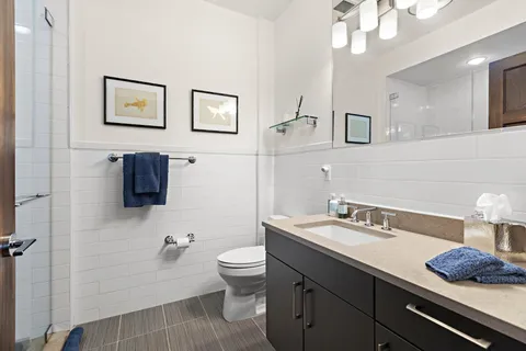 a bathroom with a sink a toilet and mirror