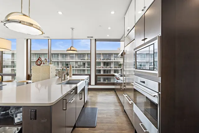 a kitchen with kitchen island a stove a sink and a refrigerator