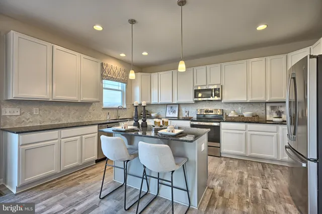 a kitchen with kitchen island granite countertop a sink a center island and cabinets