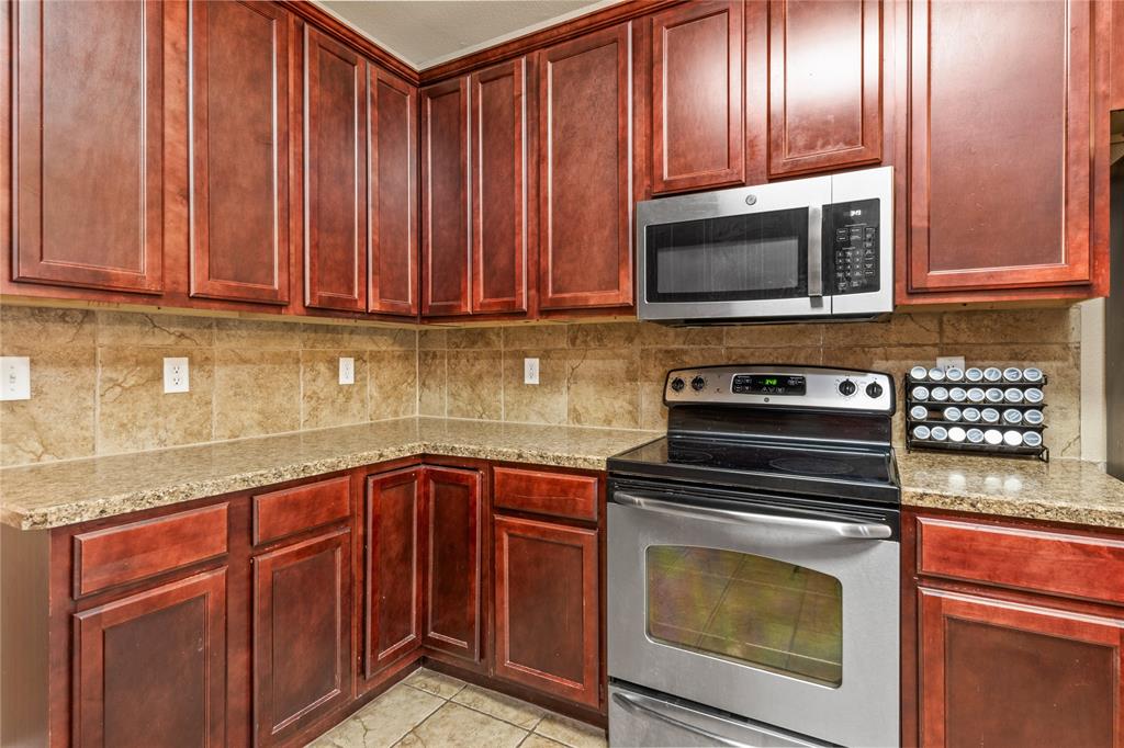 517 Austin Acre Road Sulphur Springs, TX 75482 - Photo 13 of 36 a kitchen with granite countertop wood cabinets stainless steel appliances and a sink
