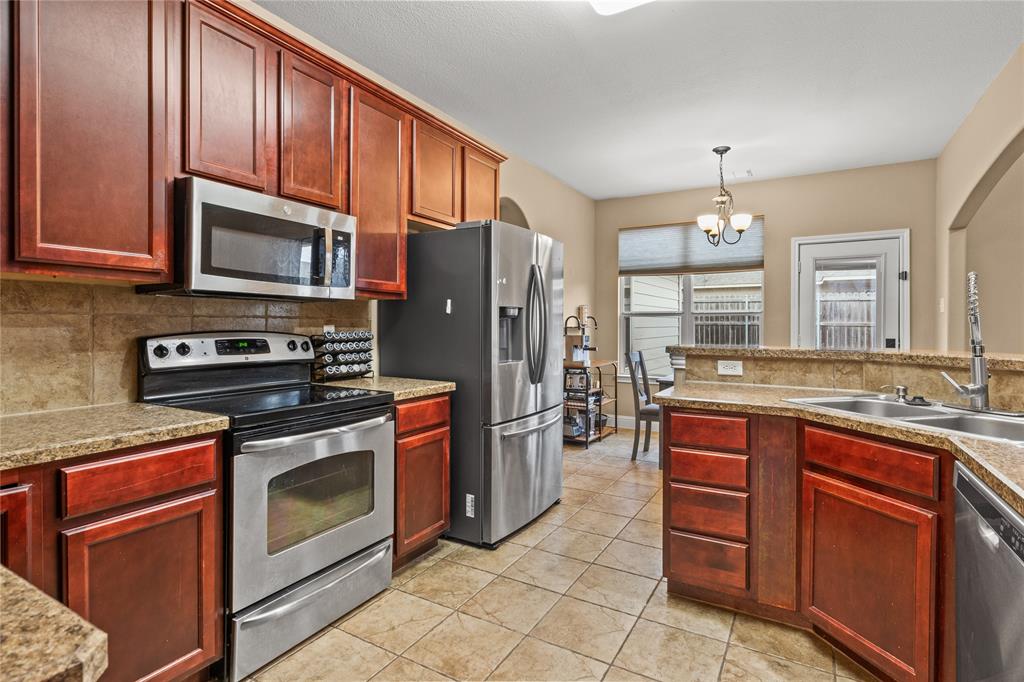 517 Austin Acre Road Sulphur Springs, TX 75482 - Photo 14 of 36 a kitchen with stainless steel appliances granite countertop a stove microwave and refrigerator