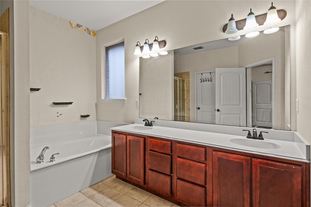 517 Austin Acre Road Sulphur Springs, TX 75482 - Photo 20 of 36 a bathroom with a tub sink double vanity and a mirror