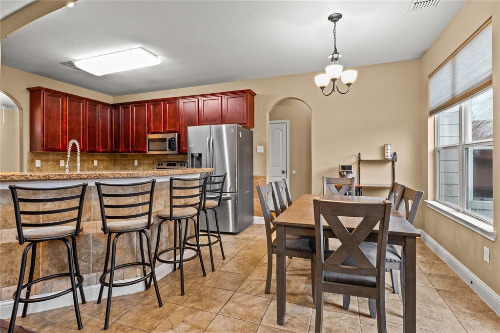 517 Austin Acre Road Sulphur Springs, TX 75482 - Photo 9 of 36 a kitchen with stainless steel appliances kitchen island granite countertop a table chairs and a refrigerator