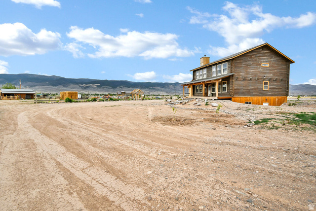 544 East 600 North, Unit 1 Joseph, UT 84739 - Photo 39 of 65 Wood-sided residence featuring a covered porch, multiple windows, and a prominent chimney