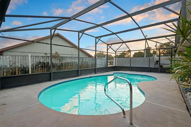 a view of a swimming pool with a patio and a yard