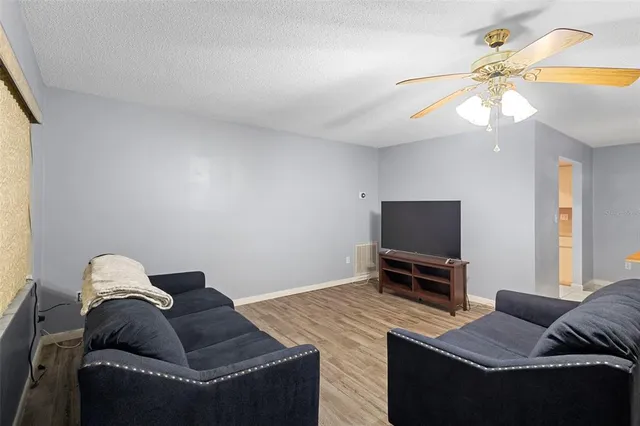 a living room with furniture a flat screen tv and a window