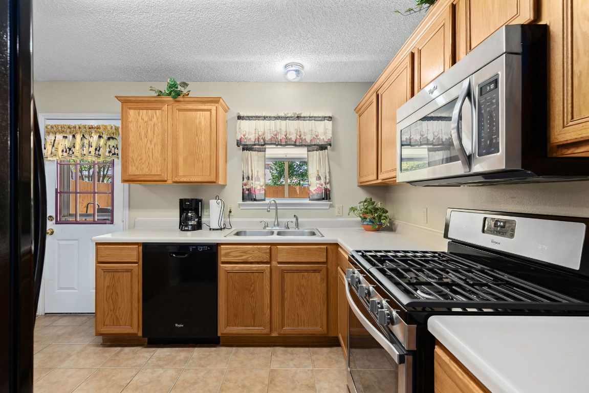 2158 Redwing Way Round Rock, TX 78664 - Photo 9 of 25 a kitchen with stainless steel appliances a sink stove and cabinets
