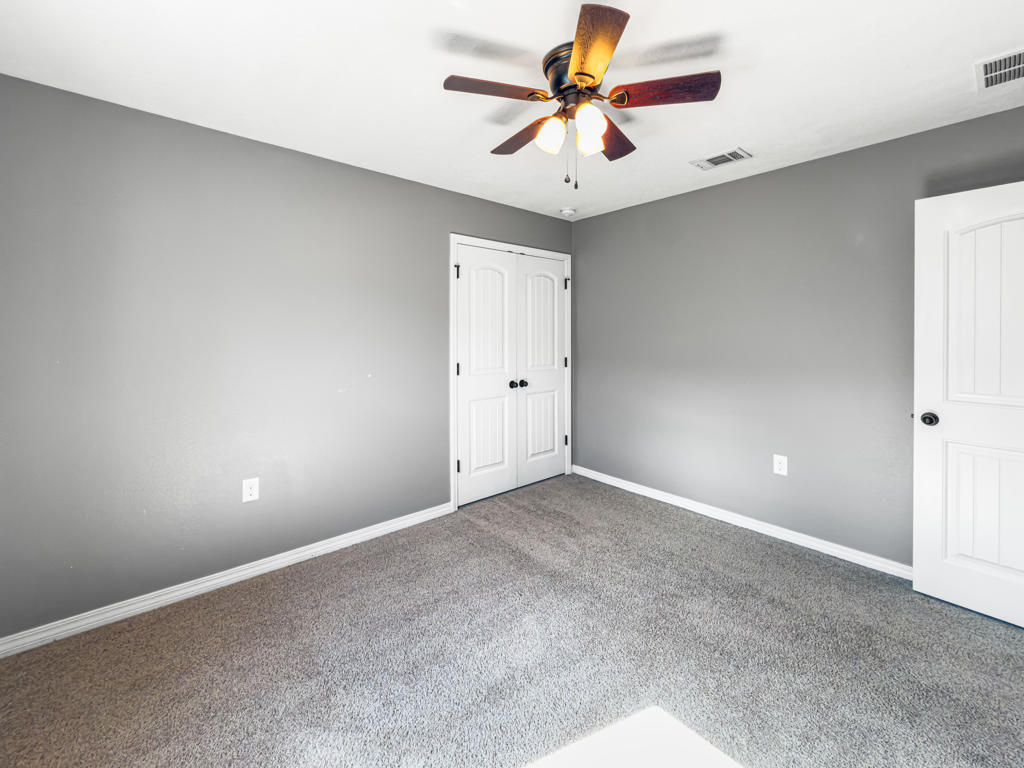 125 Lillian Way Crestview, FL 32536 - Photo 20 of 33 an empty room with a chandelier fan and a ceiling fan